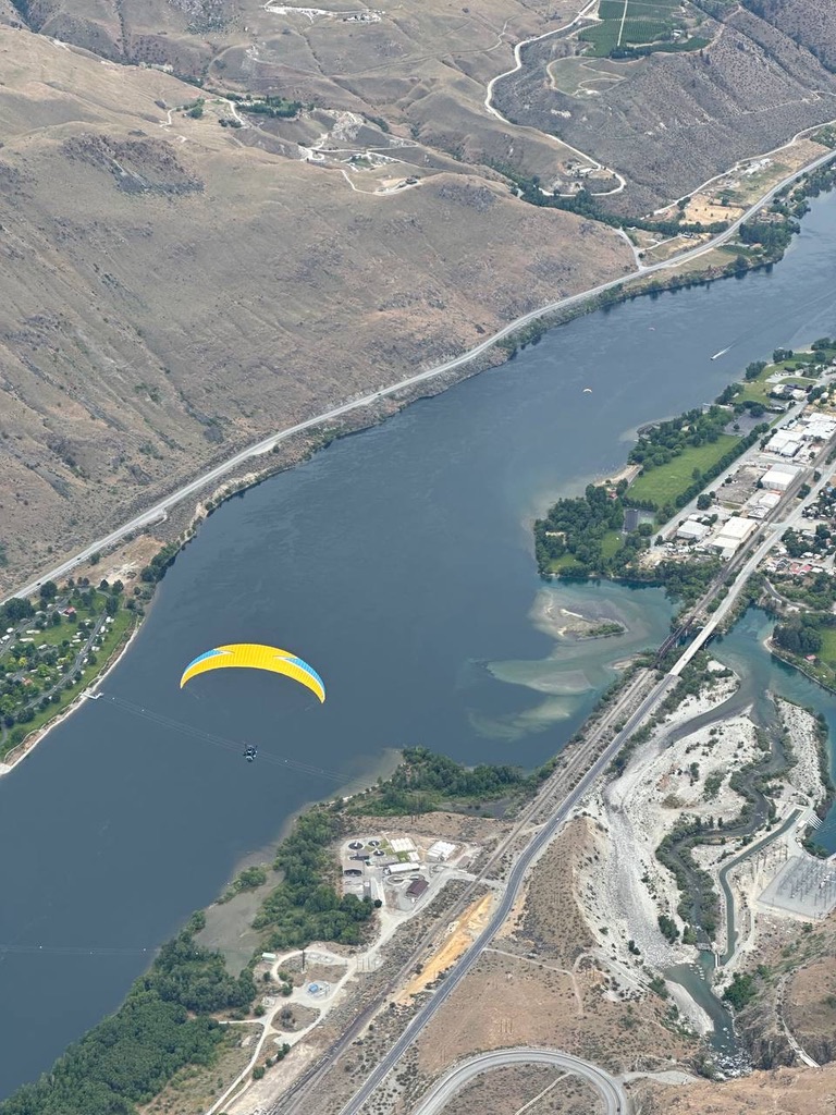 Paraglider flying over the river in Chelan